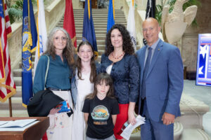 Senator Pat Stefano stands with Peggy Hoffman and her family at the Women Veterans Day ceremony, which was held at the foot of the steps of the Ryan Office Building.